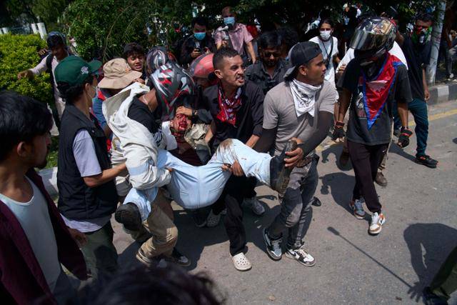 네팔에서 대규모 반정부 시위가 발생한 지난 8일 카트만두 국회의사당 앞에서 부상당한 시위자가 동료들에 의해 병원으로 옮겨지고 있다. 정부의 SNS 차단 조치에 반발한 반부패 시위가 유혈 충돌로 번지며 70명 이상이 사망했다. 카트만두=AP 연합뉴스