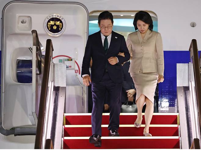 미국 방문 일정을 마치고 귀국한 이재명 대통령과 김혜경 여사가 26일 성남 서울공항에 착륙한 공군 1호기에서 내리고 있다. <연합뉴스>