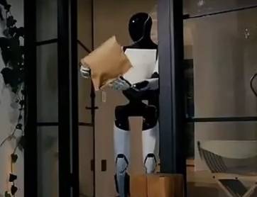 테슬라 옵티머스가 소포를 뜯고 있다.