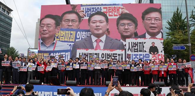 국민의힘 장동혁 대표와 송언석 원내대표를 비롯한 의원들이 28일 서울 시청역 7, 8번 출구 앞 대로에서 열린'사법파괴 입법독재 국민 규탄대회'에서 '사법파괴 입법독재 민주당은 중단하라'라고 적힌 손피켓을 들고 있다.