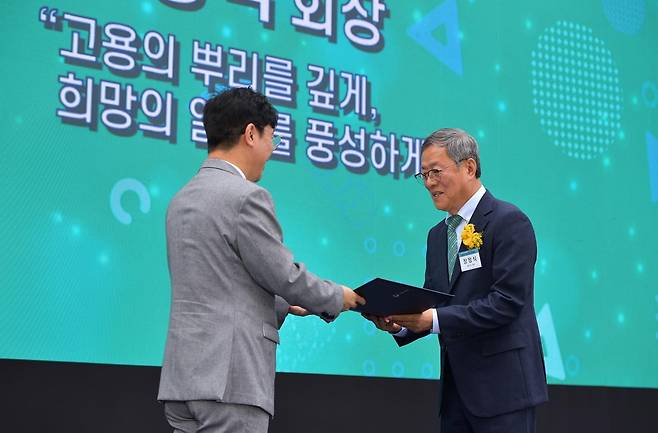 장정식 회장이 김영훈 고용노동부 장관으로부터 상을 수여받고 있다.