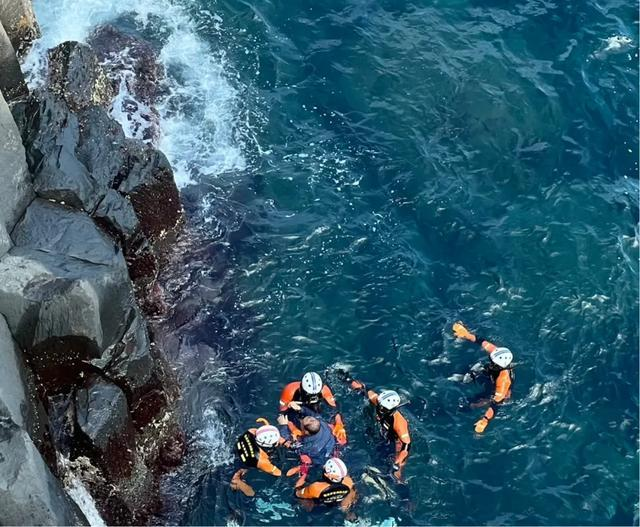 구조대가 물에 빠진 여성을 구한 뒤 중국인 양보씨를 돕고 있다.