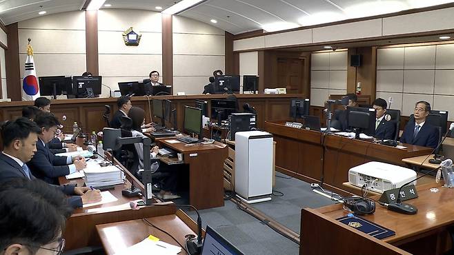 내란 우두머리 방조 혐의를 받는 한덕수 전 국무총리의 첫 재판이 30일 시작됐다. 서울중앙지법 형사합의33부(이진관 부장판사)는 이날 오전 10시 내란 우두머리 방조, 위증, 허위공문서 작성 및 행사 등 혐의로 불구속기소 된 한 전 총리의 첫 공판을 열었다. 법원 영상 캡처