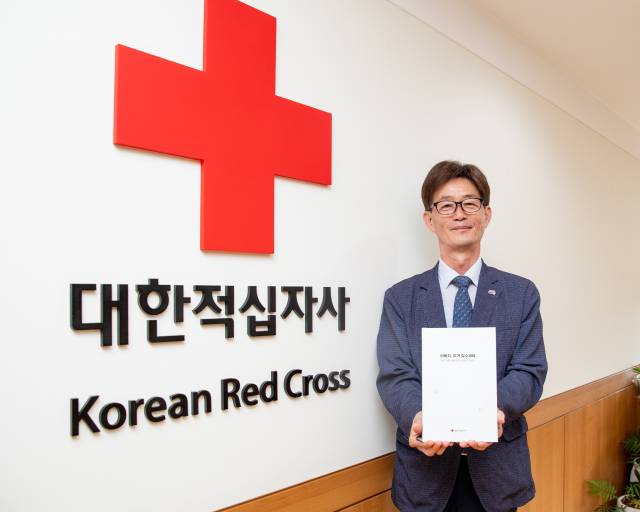 박종술 대한적십자사 사무총장이 지난해 발간된 ‘이산가족 생애보’를 들어보이고 있다. 사진 제공=대한적십자사