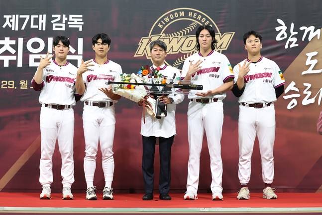 설종진 감독(가운데)이 선수단으로부터 꽃다발과 펑고 배트 선물을 받고 기념촬영을 하고 있다. 왼쪽부터 정현우, 송성문, 설종진 감독, 안우진, 김건희. /사진=키움 히어로즈 제공