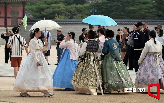한복을 입고 서울 관광에 나선 외국인들이 경복궁을 둘러보고 있다.