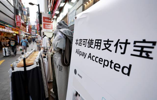 29일 서울 중구 명동 거리에 중국인 관광객들을 상대로 한 간편결제 수단 등 홍보 배너가 설치돼 있다. 이날부터 내년 6월 30일까지 국내·외 전담여행사가 모객한 3인 이상 중국인 단체관광객은 비자 없이 15일간 국내 관광을 할 수 있다. 2025.9.29. 연합뉴스