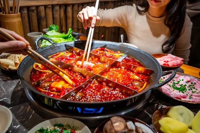 정통 마라탕을 즐기고 있는 여성들. 매운 음식을 먹은 뒤 붉은색 대변을 보면 주의깊게 살피는 게 바람직하다. 매운 음식을 먹으면 장 점막이나 항문이 자극을 받아 직장출혈 즉 혈변이 일어날 수 있다. 사진=게티이미지뱅크