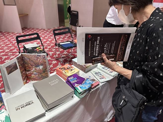 지난달 24일 일본 히로시마 JMS애스터플라자 대공연장 로비에 마련된 한국관광공사 부스에서 한 관람객이 홍보 책자를 둘러보고 있다. 정수민기자