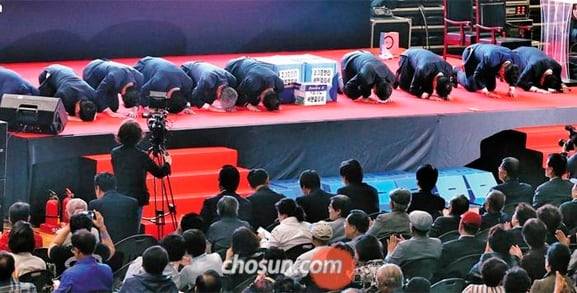 반포주공1단지 재건축에 입찰한 한 건설사 관계자들이 27일 조합 임시총회에서 사업 설명을 한 다음 조합원들에게 절을 하고 있다. 시공사 투표 결과 현대건설이 시공권을 따냈지만, 시공사 선정 과정에서 건설사 간의 비방전 등이 벌어지며 건설업계 민낯을 그대로 드러냈다.