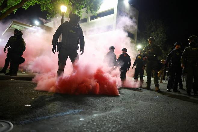 5일(현지시간) 미국 오리건주 포틀랜드 남부의 미 이민세관단속국(ICE) 본부 밖에 모인 시위대를 해산시키기 위해 법집행관들이 연막탄을 터뜨렸다. 포틀랜드 로이터 연합뉴스