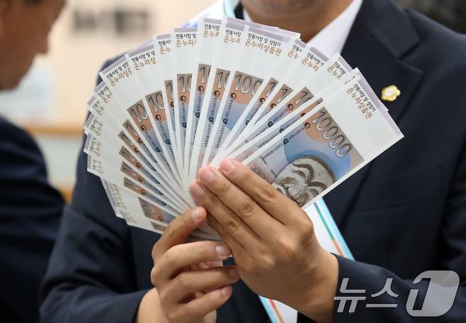 24일 오전 대구 중구 iM뱅크 중구청지점에서 열린 '추석맞이 전통시장 온누리상품권 구매 행사'에서 중구 관계자들이 전통시장 활성화를 위해 구매한 상품권을 펼쳐 보이고 있다. 2025.9.24/뉴스1 ⓒ News1 공정식 기자