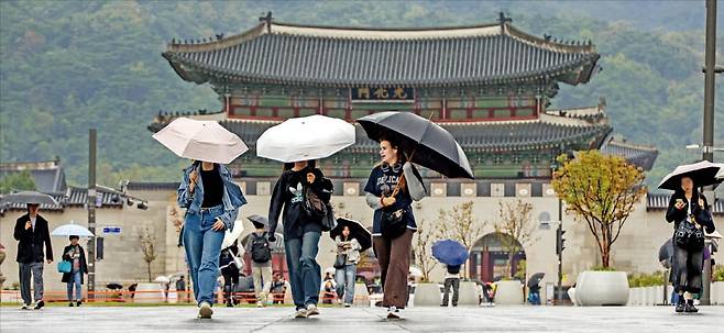 < 연휴 끝나도 비…서늘해진 아침 > 가을비에 수도권 최저 기온이 16도 안팎으로 떨어진 10일 광화문광장에서 우산을 쓴 시민과 관광객들이 발걸음을 재촉하고 있다. 기상청은 주말 동안 전국이 대체로 흐리고 수도권, 강원, 충청에 비가 온다고 예보했다. /임형택 기자