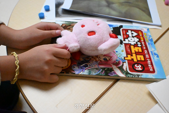 이주아양(8)이 지난 10일 서울 마포경찰서 육아N오피스에서 만난 기자에게 집에서 가져온 수학 만화책과 인형을 보여주고 있다. 강한들 기자