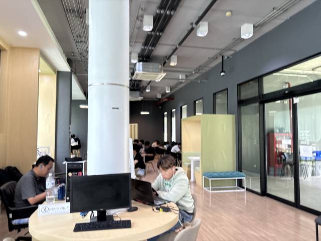 치앙마이 대학교에 위치한 워케이션 장소에서 학생들과 여행객들이 업무를 보고 있다.