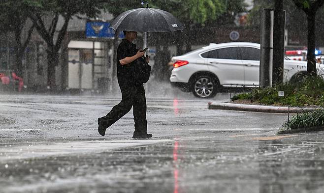 전국적으로 비가 내리는 13일 오전 서울 중구 청계광장 인근에서 우산을 쓴 한 시민이 출근길을 서두르고 있다. 임세준 기자