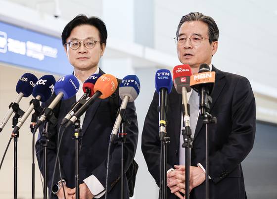 김용범 대통령실 정책실장이 15일 오전 한?미 관세 협상 후속 논의를 위해 인천공항 제2터미널을 통해 미국으로 출국하기 전 취재진의 질문에 답변하고 있다. 왼쪽은 김정관 산업통상부 장관. 김경록 기자