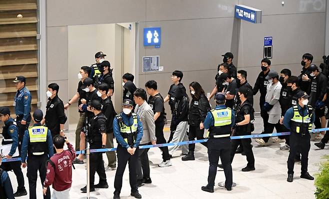 캄보디아 당국의 범죄단지 단속으로 적발돼 구금됐던 한국인들이 18일 오전 인천국제공항 2터미널을 통해 송환되고 있다. 이번 송환 대상자들은 이른바 ‘웬치’로 불리는 캄보디아 범죄단지에서 보이스피싱이나 로맨스 스캠(사기) 등 범죄에 가담한 혐의를 받고 있다. 이들은 호송 차량 23대 등을 타고 충남경찰청 등 6개 관할 경찰관서로 압송된다. (공동취재) 2025.10.18