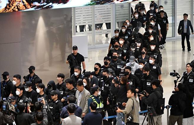 캄보디아 온라인 사기에 가담해 구금된 한국인들이 18일 오전 인천국제공항 제2터미널을 통해 송환되고 있다. 이날 송환에는 경찰 호송조 190여명이 투입됐다. 사진공동취재단