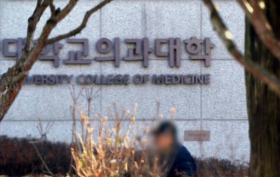 지난 1월 대전의 한 의과대학 간판 앞에 한 시민이 걸어가고 있다. 프리랜서 김성태