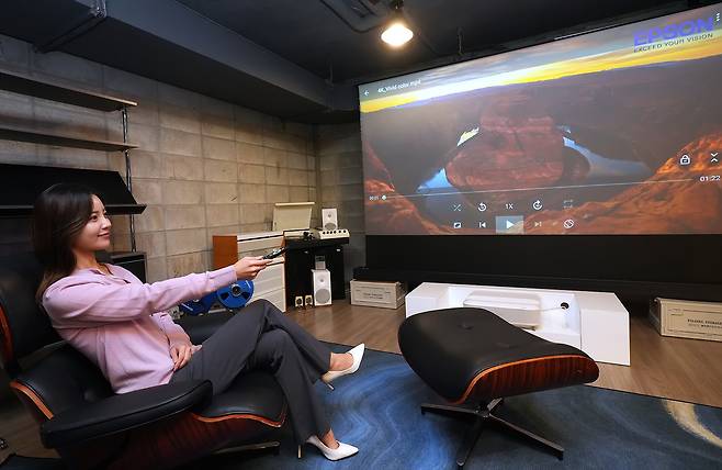 모델이 한국엡손 신제품 ‘EH-LS670’로 연출한 홈시네마를 즐기고 있다. 한국엡손 제공