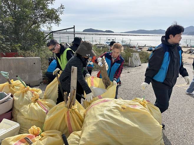 봉사자들이 21일 인천 중구 마시안 해변가에서 쓰레기를 정리하고 있다.