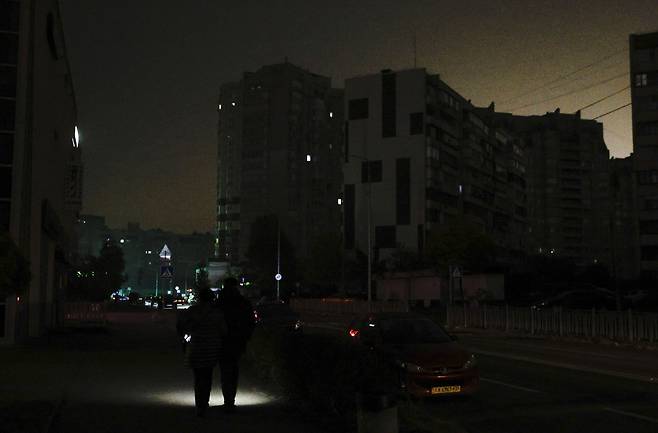 전기 끊긴 거리…평화도 ‘깜깜’ 22일(현지시간) 우크라이나 수도 키이우에서 시민들이 손전등을 비추며 밤길을 걸어가고 있다. 전날 주요 시설에 대한 러시아의 공습으로 우크라이나 일부 지역에서 전기가 끊겼다. EPA연합뉴스