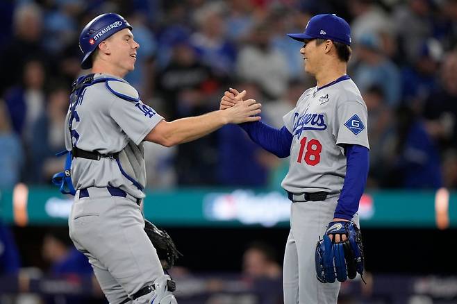LA 다저스 야마모토 요시노부(오른쪽)가 26일(한국시간) 로저스센터에서 열린 토론토와 WS 2차전에 선발등판해 9이닝 4안타 1사구 8탈삼진 1실점의 완투승을 거뒀다. PO 2차전에 이은 올해 PS 2연속 완투승이다. 경기 후 포수 윌 스미스와 하이파이브하는 야마모토. 토론토(캐나다 온타리오주)|AP뉴시스