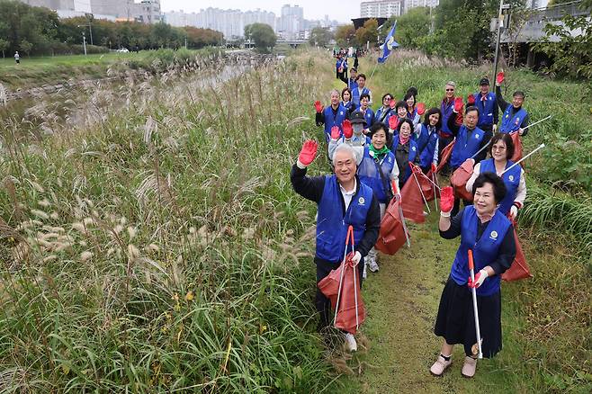 바르게살기운동 회원들이 광주천변에서 쓰레기를 줍고 있다. 김양배 기자