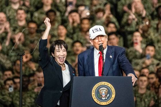 지난 28일 일본 요코스카 미 해군기지에 정박한 핵추진항모 조지 워싱턴함에서 트럼프 대통령의 소개로 다카이치 사나에 일본 총리가 손을 번쩍 들어보이고 있다. 다카이치 총리는 이날 일본 총리 중 처음으로 미 핵추진항모에서 연설했다. AFP=연합뉴스