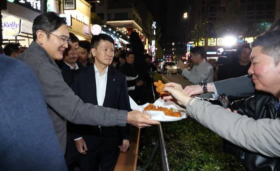 이재용 삼성전자 회장이가 30일 서울 강남구 깐부치킨 삼성점에서 젠슨황 엔비디아 최고경영자와 '치맥' 회동 중 시민들에게 치킨을 나눠주고 있다. 뉴스1