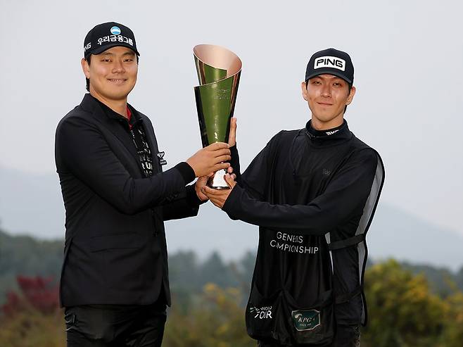 지난 26일 끝난 제네시스 챔피언십에서 우승한 이정환이 캐디백을 맨 동생 정훈((오른쪽)씨와 트로피를 들고 포즈를 취하고 있다. KPGA