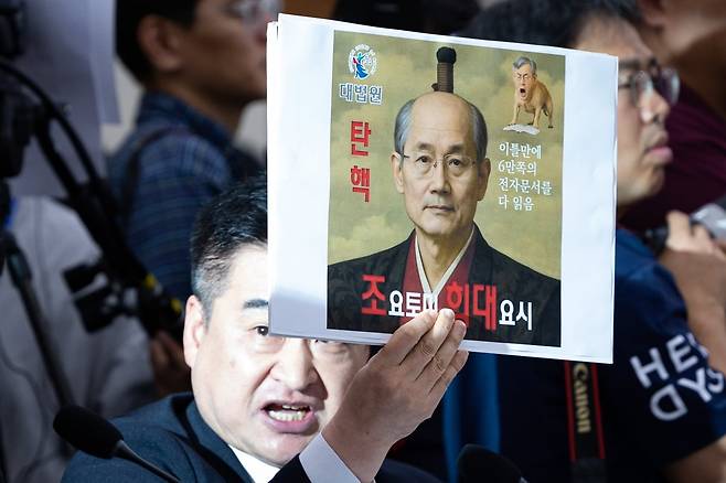 최혁진 무소속 의원이 13일 서울 여의도 국회에서 열린 법제사법위원회의 대법원 등에 대한 국정감사에서 조희대 대법원장에게 질의하며 손팻말을 들어보이고 있다. / 사진=뉴스1