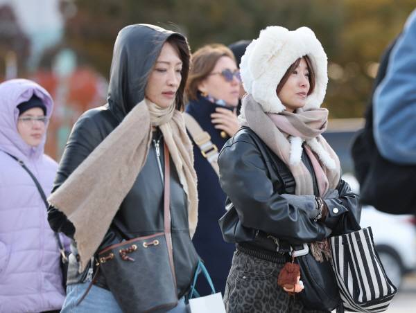 추운 날씨를 보인 2일 서울 광화문 광장에서 외국인 관광객들이 외투를 입은 채 걸어가고 있다. 연합뉴스