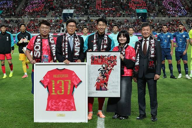 축구대표팀 주장 손흥민이 지난달 파라과이전에 앞서 A매치 역대 최다 출전 기록(137경기) 기념 유니폼을 전달받은 뒤 차범근 전 감독, 정몽규 대한축구협회장 등 관계자들과 기념사진을 찍고 있다. 연합뉴스