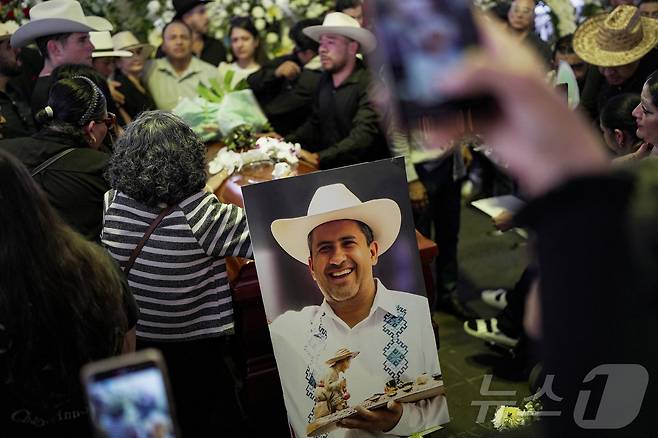 2일(현지시간) 멕시코 우루아판에서 열린 죽음의 날 행사 중 총에 맞아 사망한 카를로스 만조 시장의 장례식에 가족과 친구들이 참석했다. 2025.11.03. ⓒ 로이터=뉴스1 ⓒ News1 이정환 기자