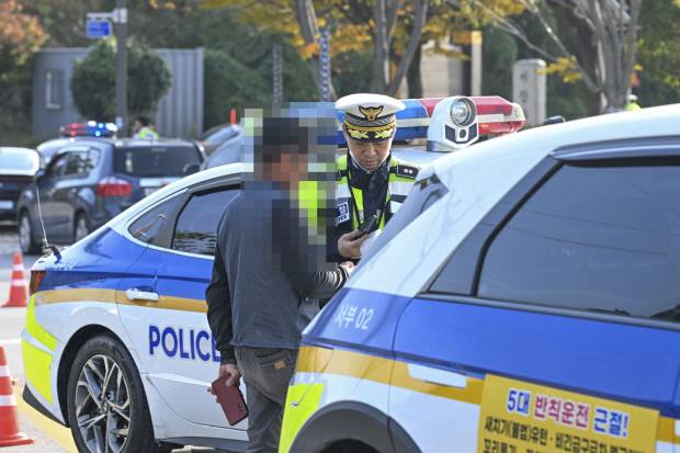 6일 오후 광주시 서구 신서창교 인근에서 광주경찰이 음주 단속을 진행한 가운데, 단속에 적발된 한 운전자가 신원조회 결과 과거 음주로 적발된 이력이 확인돼 ‘2진 아웃’으로 면허 취소 안내를 받고 있다. /김진수 기자 jeans@kwangju.co.kr