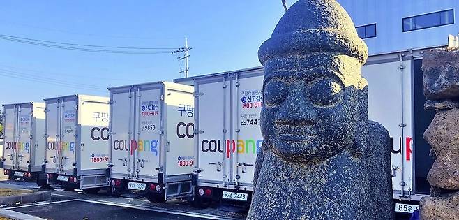 Coupang delivery trucks are lined up at a logistics site in Jeju, where the company began offering overnight fresh‑food delivery for the first time on the island starting February this year. (Coupang)