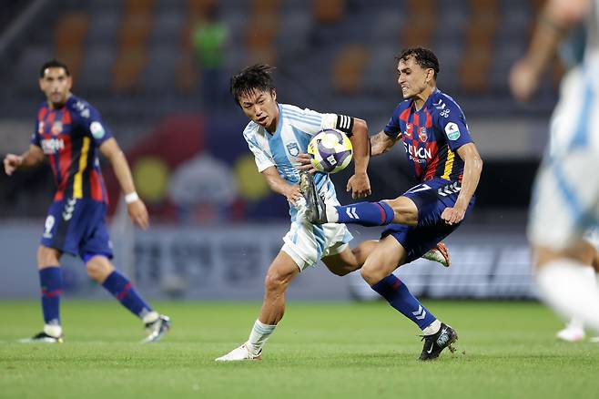 K리그1 울산 HD 고승범(가운데)이 지난 8월 16일 수원FC와의 원정 경기에서 루안과 볼을 다투고 있다. 프로축구연맹 제공