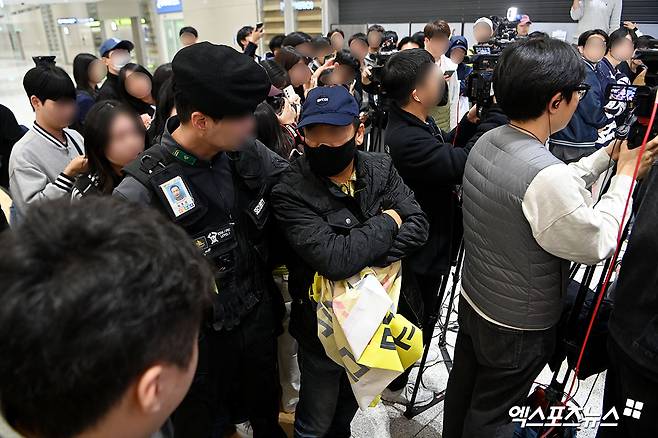 미국프로야구 메이저리그(MLB) 로스앤젤레스 다저스에서 뛰는 김혜성이 월드시리즈 우승반지와 함께 6일 오후 인천국제공항을 통해 귀국했다. 김혜성이 입국장을 나서 취재진과 인터뷰 중 한 남성이 김혜성과 김혜성의 부친을 비난하는 기습 시위를 하고 있다. 인천공항, 고아라 기자