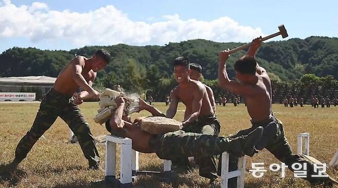 방탄복이 없으니, 배 근육을 키워야 하는 걸까. 김정은이 참관하는 행사 때마다 배에 올려놓은 돌을 망치로 부수는 차력쇼가 빠지지 않고 등장한다. 동아일보 DB
