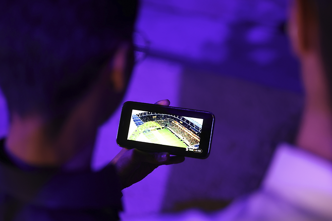 휴대전화로 축구를 관전하고 있는 팬. 기사 내용과 직접적인 관련이 없음. 게티이미지