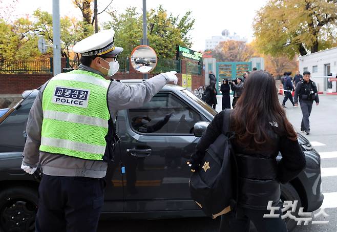2026학년도 수능일인 13일 오전 한 수험생이 차량에서 하차 후 경찰의 안내를 받으며 서울 중구 이화여자외국어고등학교 시험실로 향하고 있다. 황진환 기자