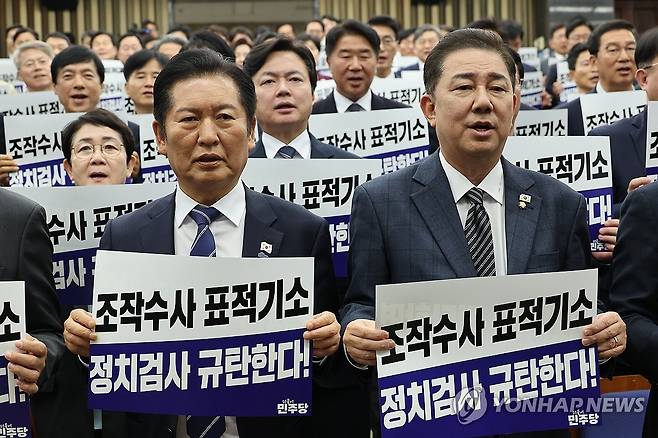 더불어민주당 의원총회 (서울=연합뉴스) 박동주 기자 = 더불어민주당 정청래 대표와 김병기 원내대표가 13일 서울 여의도 국회에서 열린 의원총회에서 "정치검사 규탄한다!"라고 적힌 팻말을 들고 구호를 외치고 있다. 2025.11.13 pdj6635@yna.co.kr