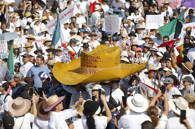 멕시코 할리스코주 과달라하라에서 15일(현지시간) 정부의 치안 부실 등에 항의하는 시위가 열린 가운데 참가자들이 대형 밀짚모자를 들고 행진하고 있다. EPA연합뉴스