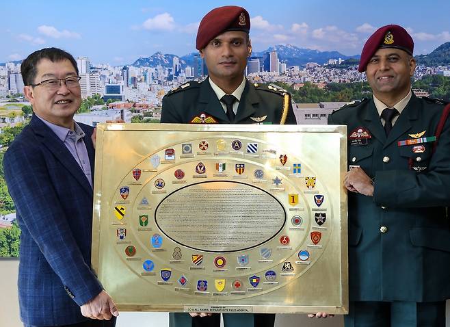 백승주 전쟁기념사업회장(왼쪽)이 지난 15일 방한한 자그닛 길 인도 제60공수야전병원장(오른쪽) 일행이 기증한 인도군 6·25 전쟁 참전 기념패를 함께 든 채 기념촬영을 하고 있다. 전쟁기념사업회 제공