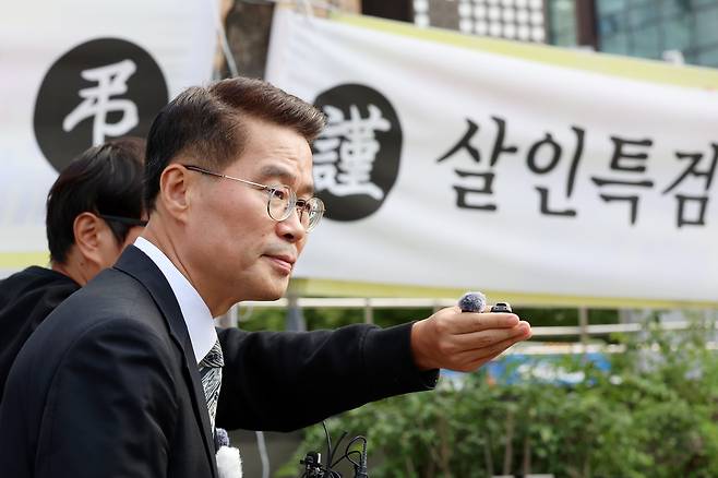 김건희 여사 일가의 '양평 공흥지구 개발 특혜 의혹'으로 김건희 특검 조사를 받은 뒤 스스로 목숨을 끊은 양평군청 사무관 측 박경호 변호사가 지난달 14일 특검 사무실이 마련된 서울 종로구 KT광화문빌딩 앞에서 기자회견 열고 있는 모습. 박 변호사 뒤로 '살인 특검'이라고 적힌 플래카드가 걸려 있다./뉴시스