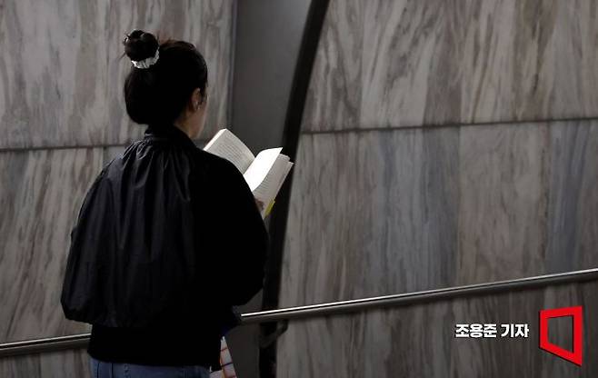 세계 책의날인 4월23일 서울 종로구 광화문역에서 출근길에 나선 한 시민이 책을 보며 걷고 있다. 사진=조용준 기자 jun21@