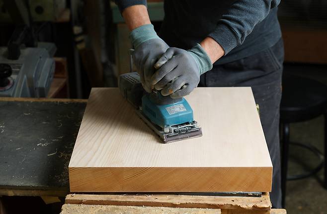 1차 대패를 마친 바둑판을 반들반들하게 다듬어 내고 있다.