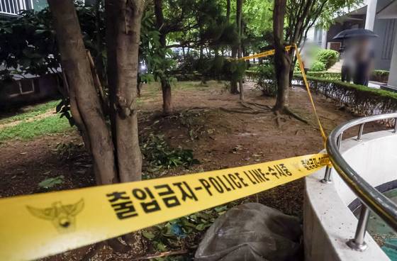 지난 6월 21일 오전 고등학생 3명이 함께 숨진 채 발견된 부산 해운대구 한 아파트 화단. 경찰이 폴리스라인으로 출입을 통제하고 있다. 중앙포토